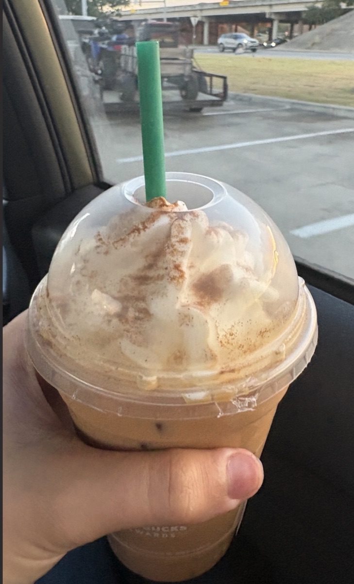 An iced coffee held in a car.
