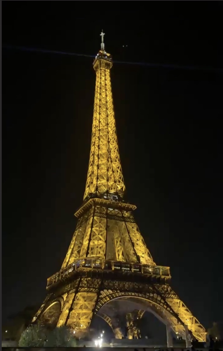 A lit tower glowing against a night sky.